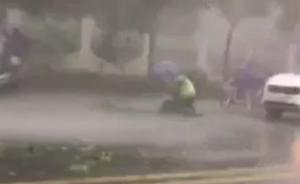 男子滑倒在车流中，交警施救遮伞保护