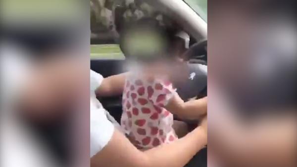 男子抱2岁娃开车拍视频发群，长辈举报
