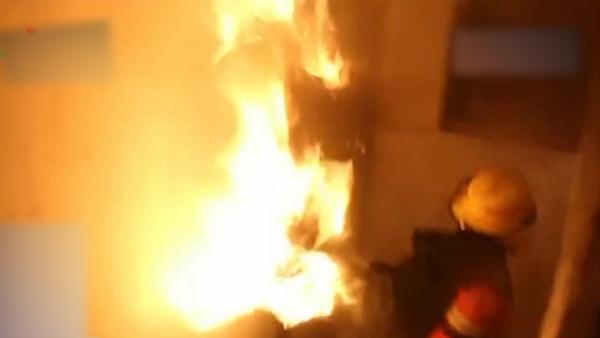 消防员抱喷火煤气罐下楼摔倒，队友接力