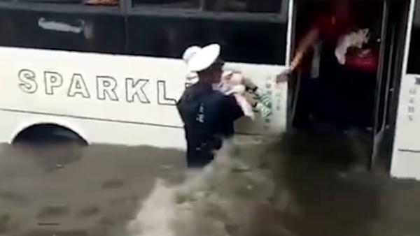 铁岭大雨:积水及腰,辅警趟水转移乘客
