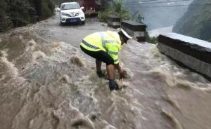 洪水致大量石块堆积，交警卷起裤腿清障
