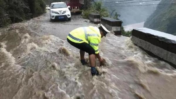 洪水致大量石块堆积，交警卷起裤腿清障