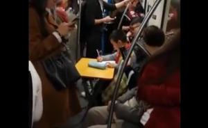 上海一学生自备折叠桌在地铁里写作业