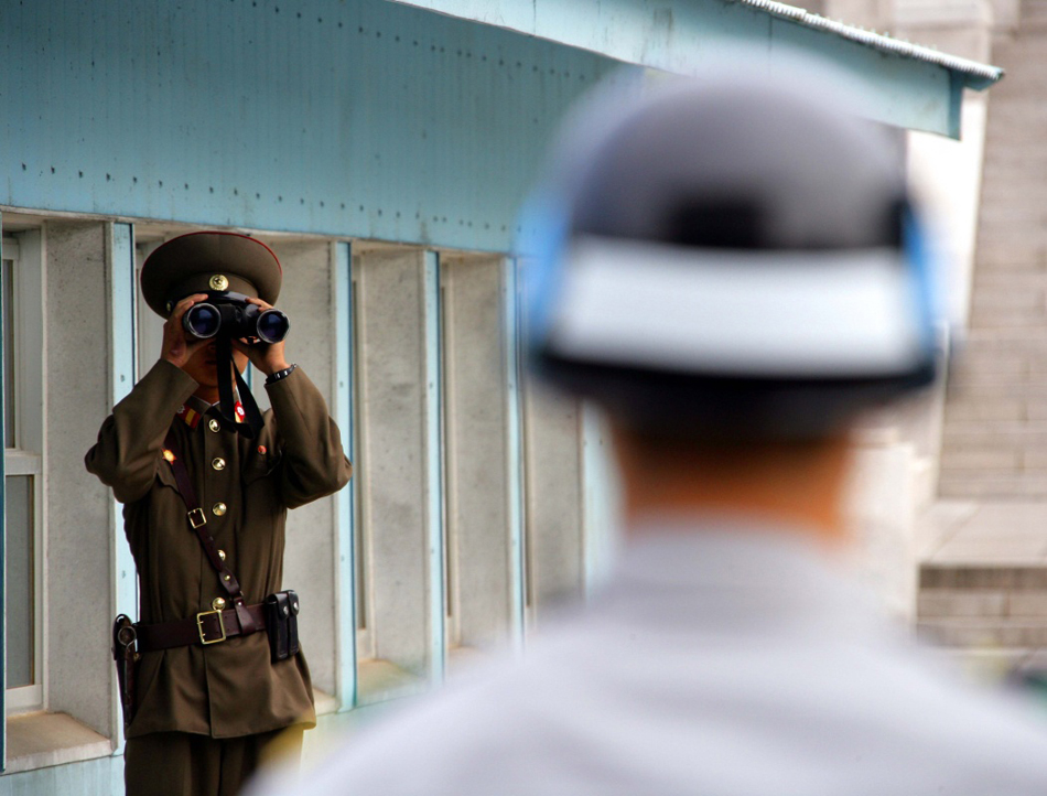 10-12-2007年10月4日拍摄的资料照片显示，在朝鲜半岛中部的板门店，一名韩国宪兵（右）和一名朝鲜人民军士兵分别在军事分界线两侧执勤。