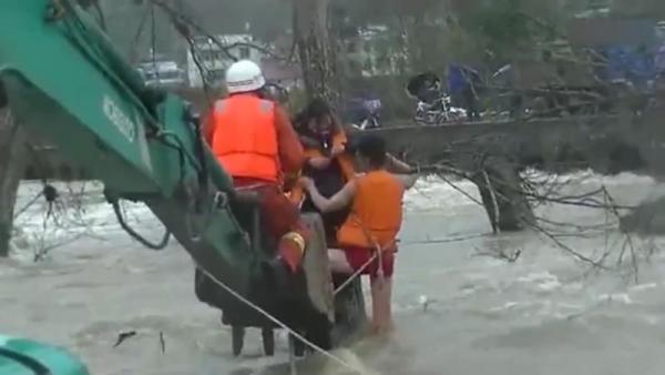女子被洪水围困树上，消防用挖掘机救人
