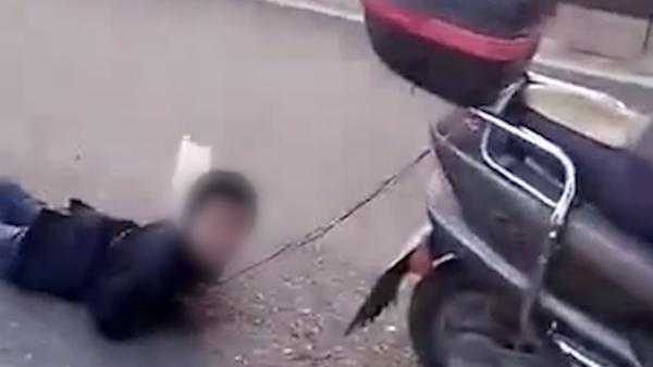 实拍：男童被母亲拴在摩托车后“拖行”