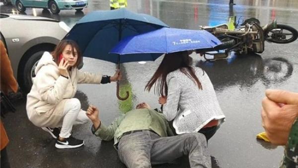 车祸伤者雨中倒地，路人撑伞20分钟