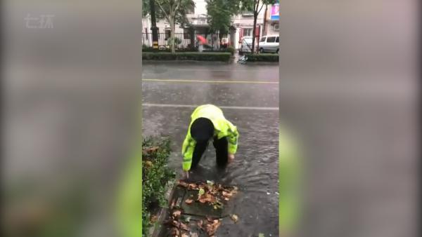 台风天树叶堵塞排水，交警涉水徒手清理